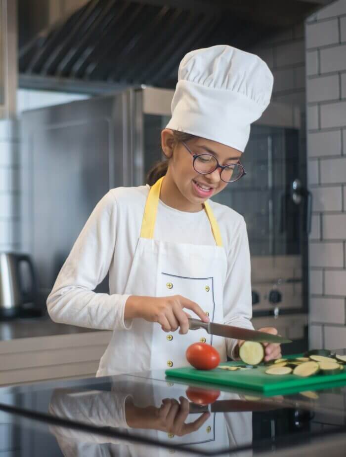 girl in chef hat cooking